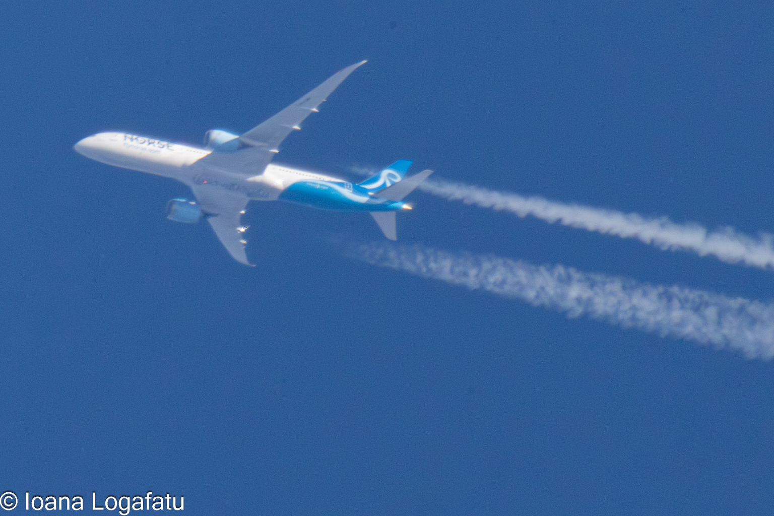 Airplane soaring through a cloudless blue sky